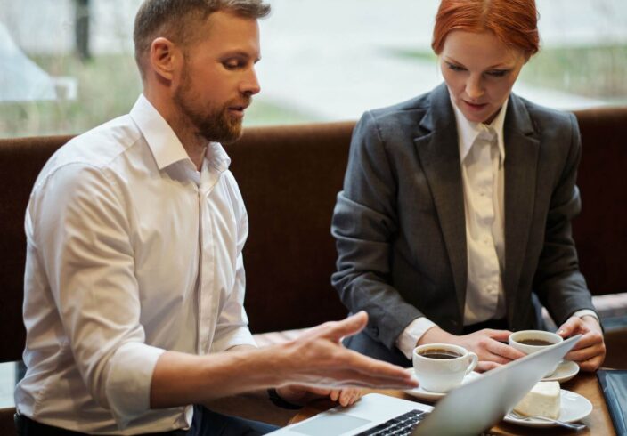 Two people having coffee looking at a laptop