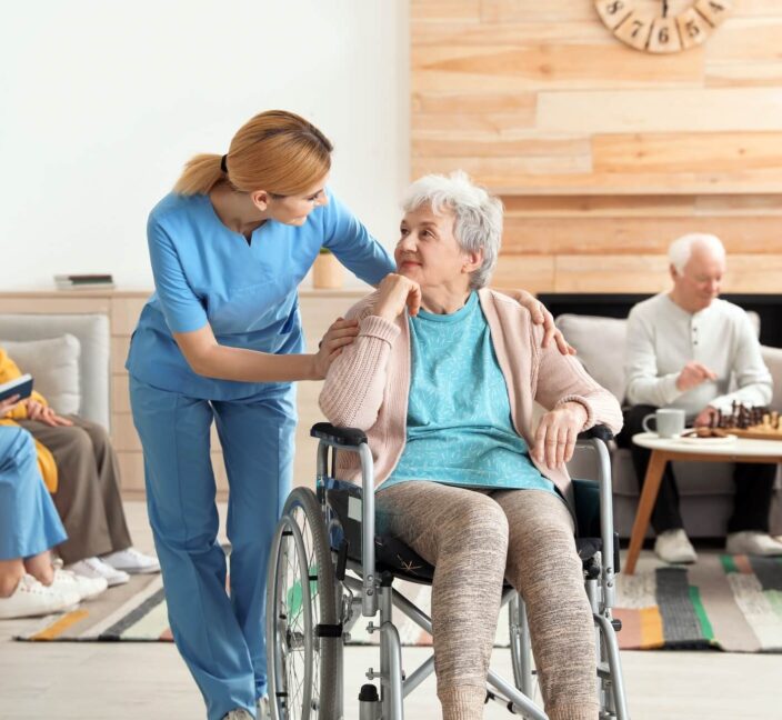 Carer talking to an elderly person in a wheelchair