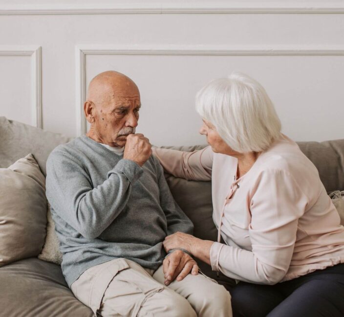 Elderly couple at home sitting on sofa